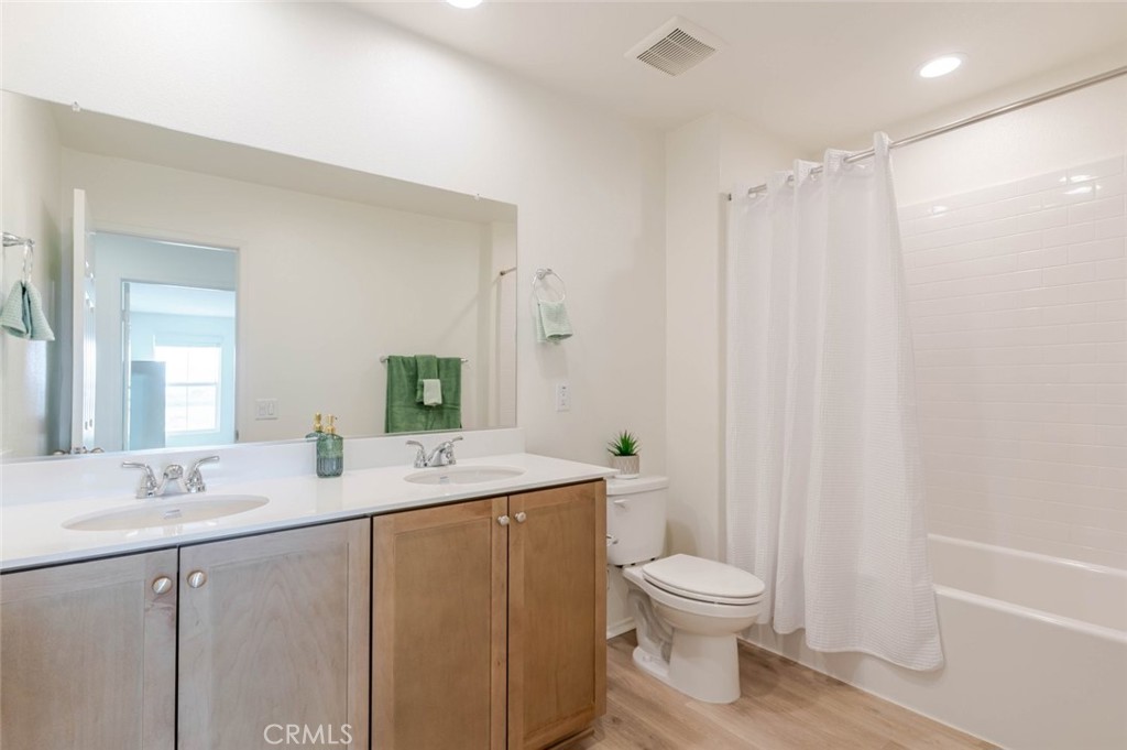 2133 East Kettering Street Lancaster, CA 93535 - Photo 17 of 32 a bathroom with a granite countertop sink toilet a large mirror and shower