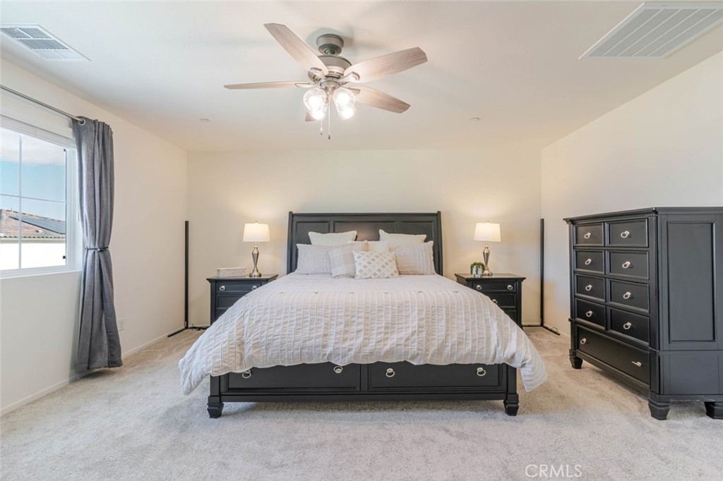 2133 East Kettering Street Lancaster, CA 93535 - Photo 19 of 32 a spacious bedroom with a bed and a chandelier