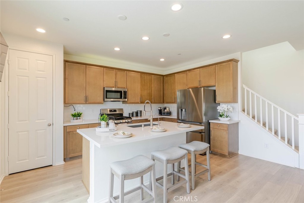 2133 East Kettering Street Lancaster, CA 93535 - Photo 6 of 32 a kitchen with stainless steel appliances granite countertop a refrigerator a stove top oven a sink dishwasher and white cabinets with wooden floor