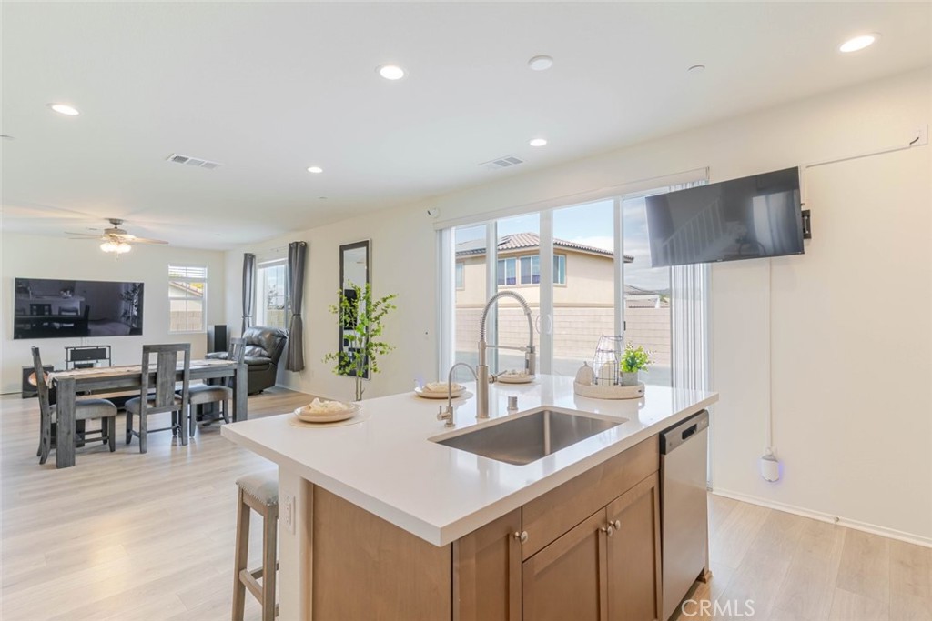 2133 East Kettering Street Lancaster, CA 93535 - Photo 8 of 32 a kitchen with sink refrigerator and dining table
