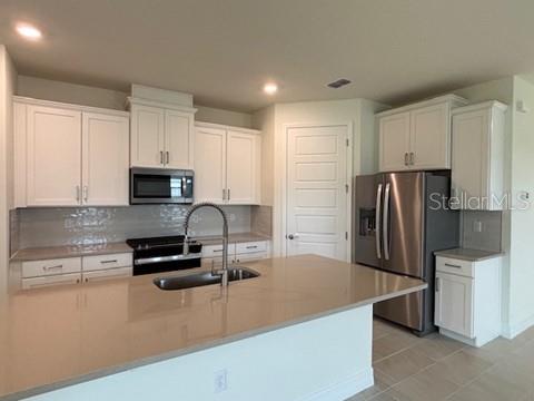 3974 Kennebunk Loop Mount Dora, FL 32757 - Photo 2 of 14 a kitchen with kitchen island a refrigerator sink and stove