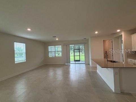 3974 Kennebunk Loop Mount Dora, FL 32757 - Photo 4 of 14 an empty room with wooden floor and windows
