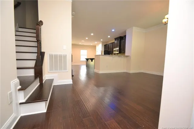 a view of a living room with wooden floor and windows
