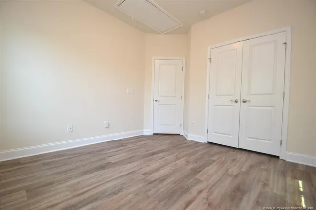 a view of an empty room with wooden floor