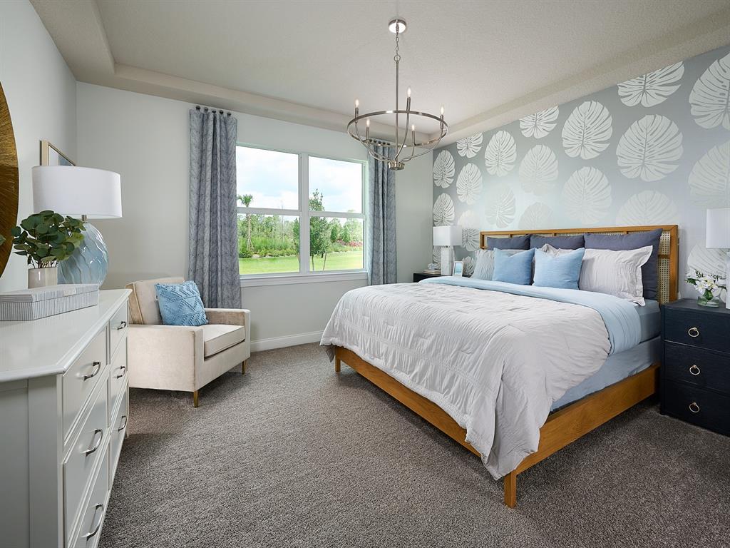 392 Birkdale Drive Daytona Beach, FL 32124 - Photo 5 of 6 a spacious bedroom with a bed and a chandelier