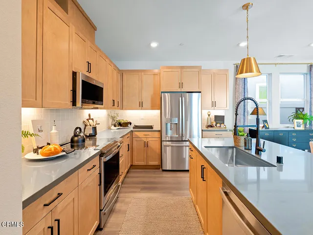 a kitchen with a sink a counter top space stainless steel appliances and cabinets