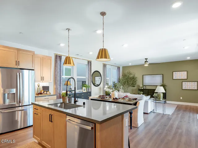 a kitchen with granite countertop a sink cabinets and stainless steel appliances