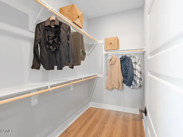 a view of walk in closet with clothes and shoes