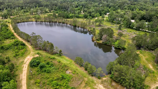 an aerial view of a house with a yard and lake view