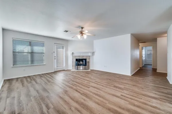 a view of an empty room with a fireplace and a window