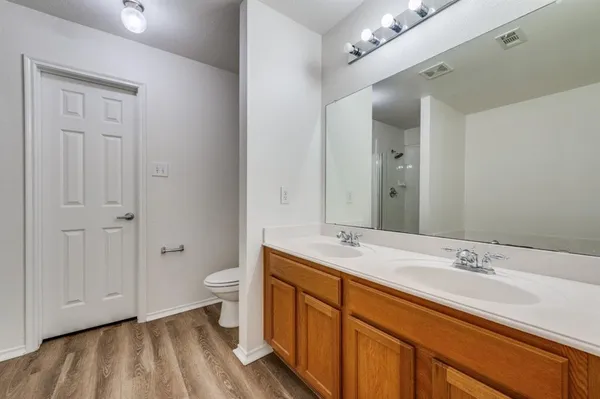 a spacious bathroom with a double vanity sink toilet and shower
