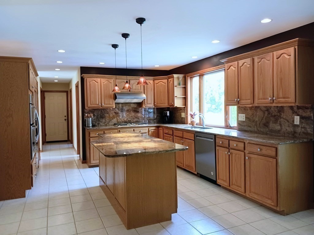 6 Winn Road Nashua, NH 03062 - Photo 8 of 33 a kitchen with stainless steel appliances granite countertop a stove a sink and a refrigerator