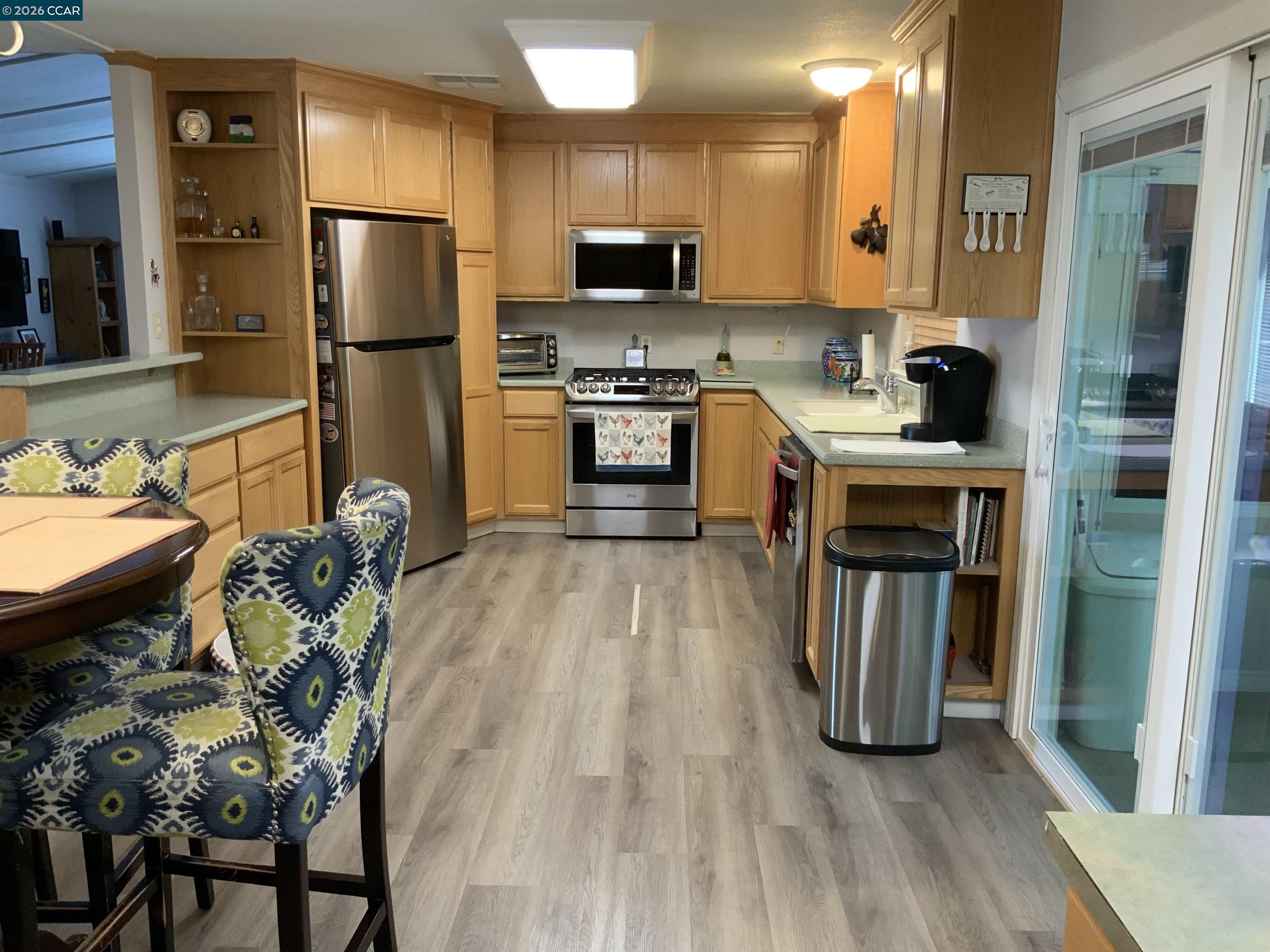 238 Aloha Pittsburg, CA 94565 - Photo 11 of 42 a kitchen with kitchen island granite countertop a refrigerator oven a sink a stove and a dining table with wooden floor