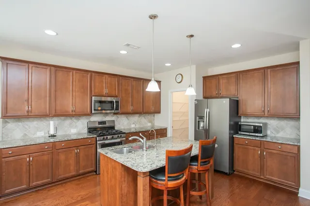 a kitchen with stainless steel appliances granite countertop a refrigerator stove microwave and sink