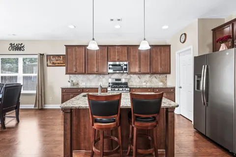 a kitchen with kitchen island a wooden table and chairs