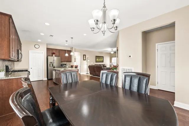 a view of a dining room with furniture a chandelier and wooden floor