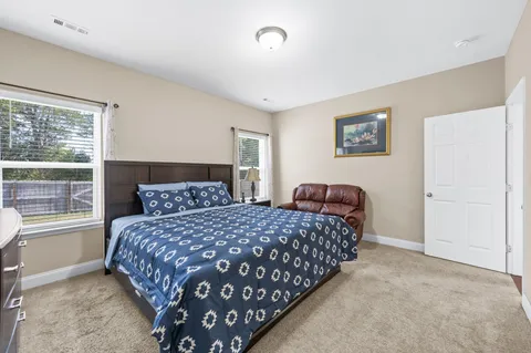 a bedroom with a bed and dresser next to a window