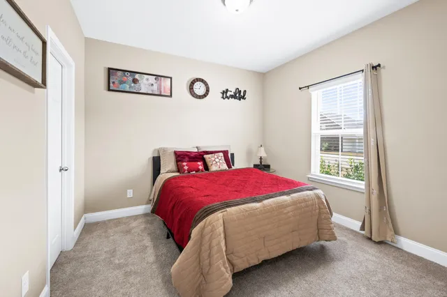 a bed sitting in a bedroom next to a window