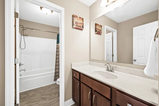 a bathroom with a shower sink vanity and mirror