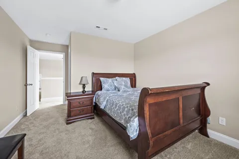 a bed sitting in a room next to a lamp