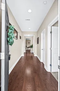 a view of a hallway with wooden floor and a living room