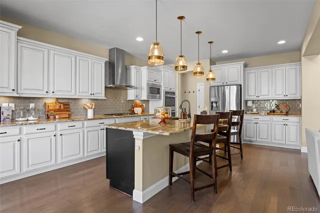 a kitchen with kitchen island granite countertop wooden cabinets and white stainless steel appliances