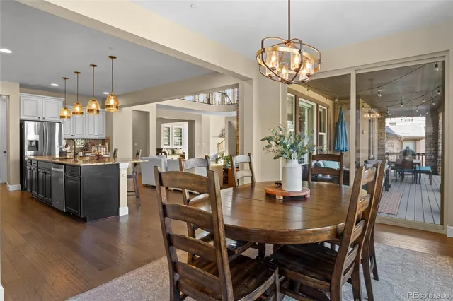 a dining room with furniture a chandelier and wooden floor