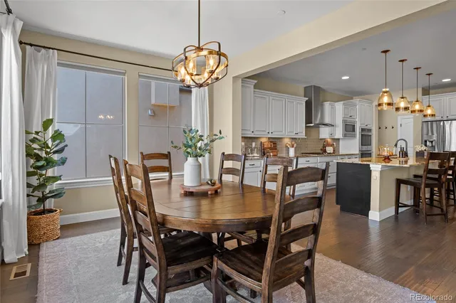 a view of a dining room and livingroom with furniture wooden floor a chandelier