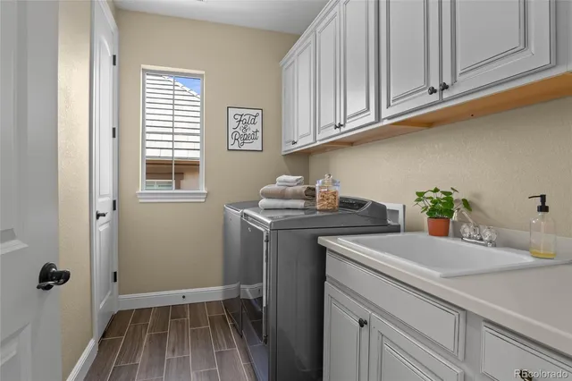 a utility room with cabinets washer and dryer