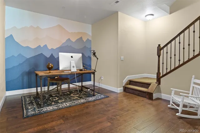 a work room with furniture and a wooden floor