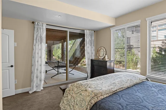 a bedroom with a bed a table and windows