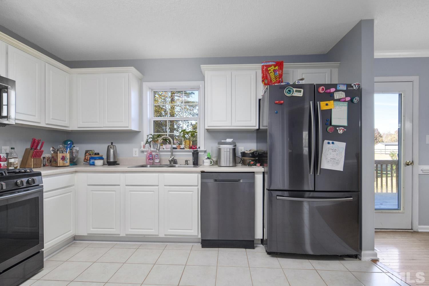 476 Saddle Ridge Drive Willow Spring, NC 27592 - Photo 12 of 30 a kitchen with a refrigerator and cabinets