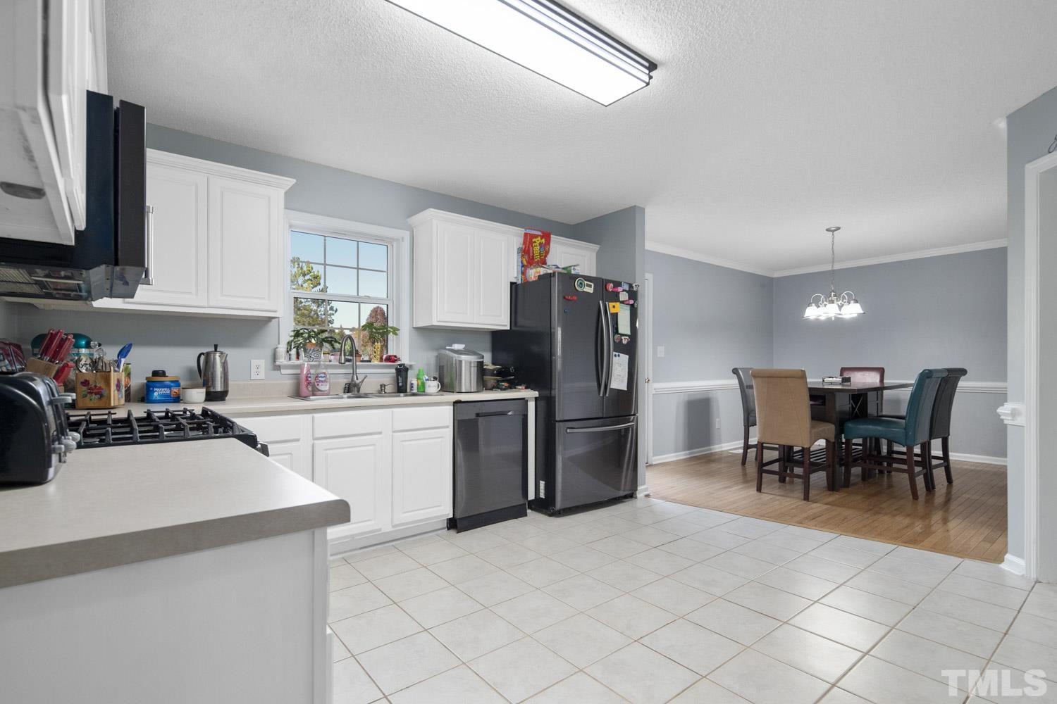 476 Saddle Ridge Drive Willow Spring, NC 27592 - Photo 13 of 30 a kitchen with a dining table chairs and refrigerator