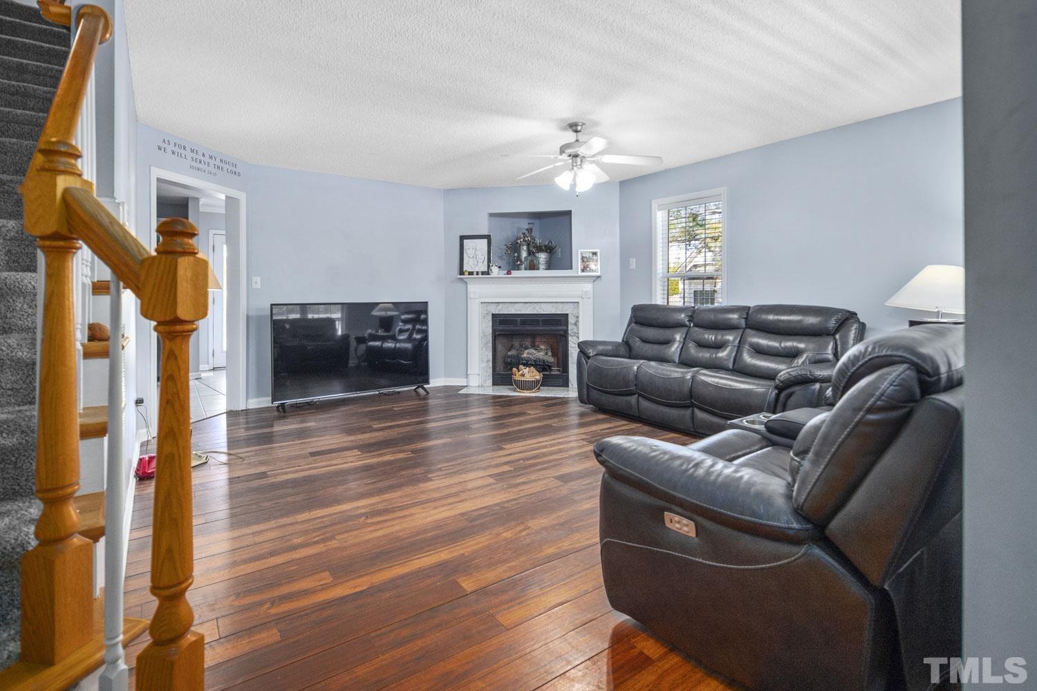 476 Saddle Ridge Drive Willow Spring, NC 27592 - Photo 6 of 30 a living room with furniture a fireplace and a flat screen tv