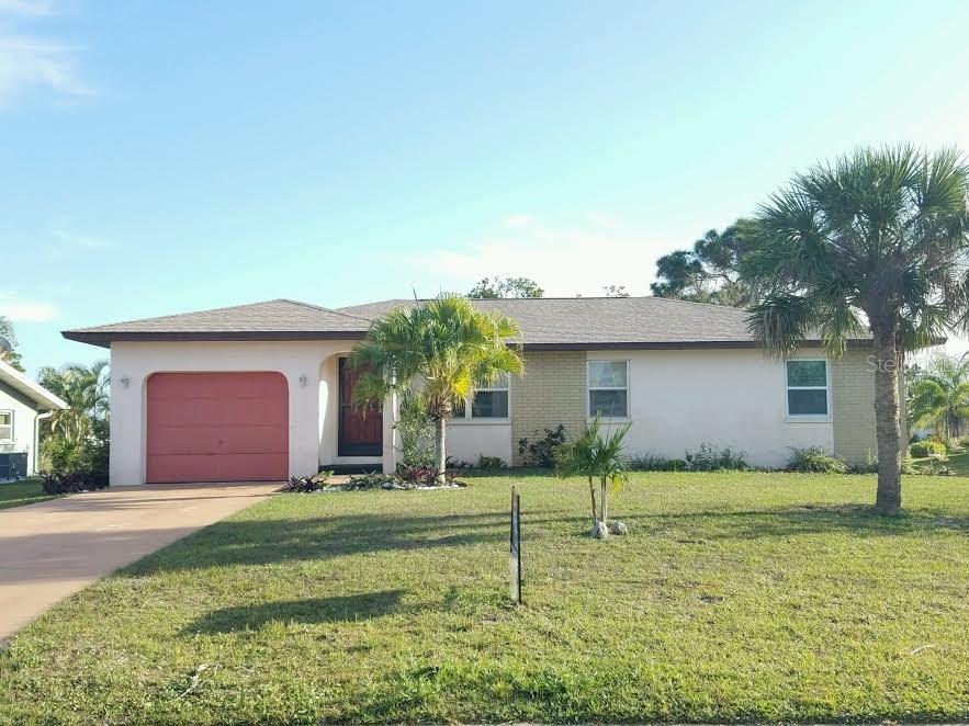 Front of home with NEW roof and mature trees and plants.