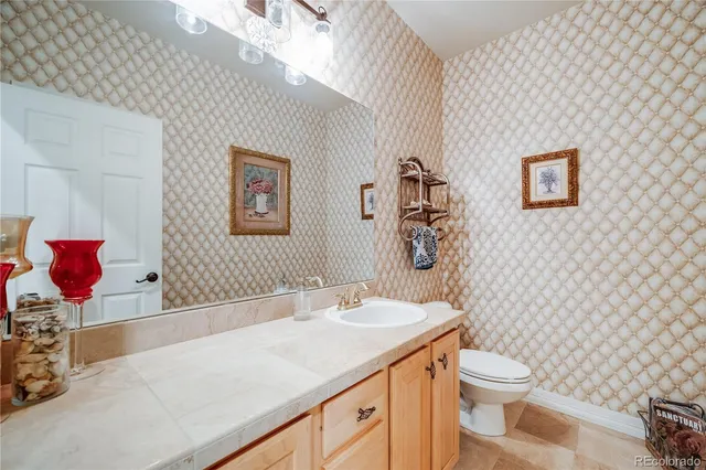 a bathroom with a granite countertop toilet sink and mirror