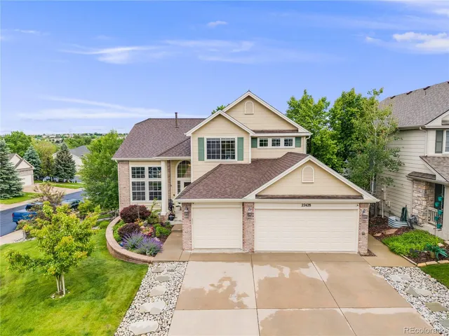 a view of a white house with a yard and potted plants