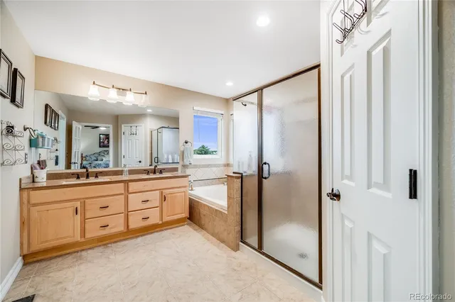a bathroom with a granite countertop sink mirror and a bathtub