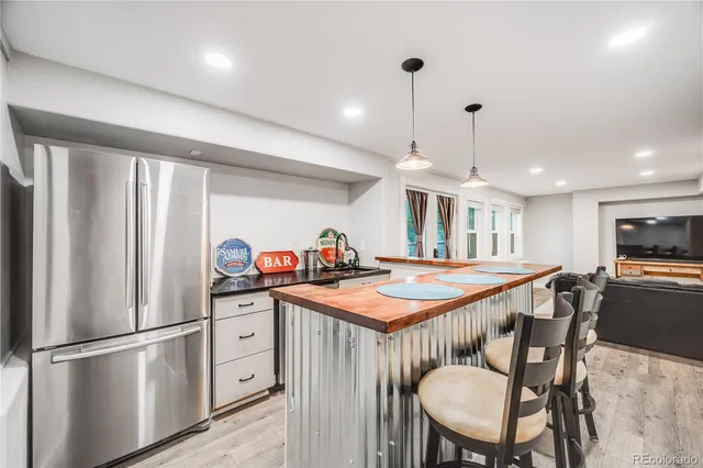 a kitchen with stainless steel appliances granite countertop a table chairs sink and cabinets