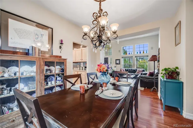 a view of a dining room with furniture a chandelier and wooden floor