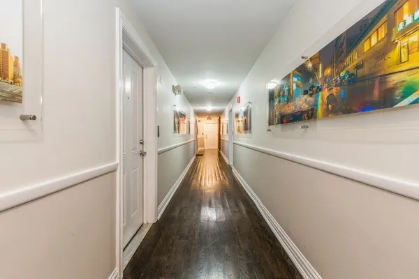a view of a hallway with wooden floor