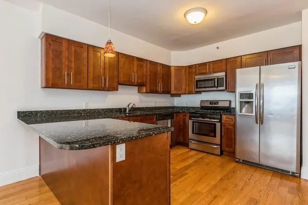 a kitchen with stainless steel appliances granite countertop a sink stove and refrigerator