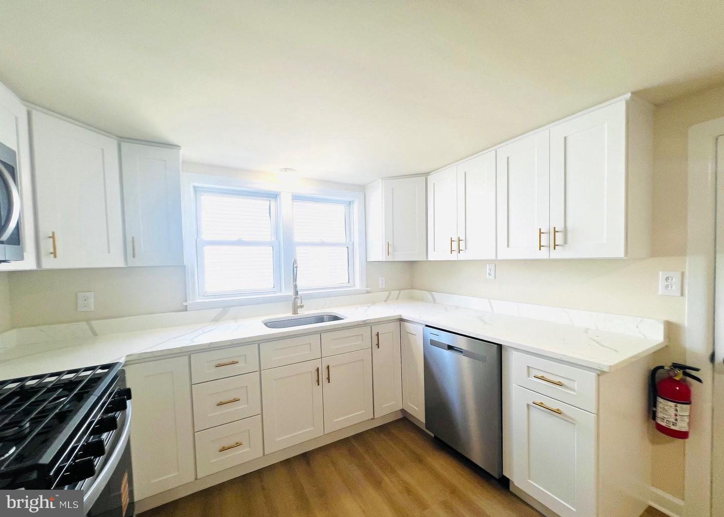 617 3rd Street Beverly, NJ 08010 - Photo 5 of 16 a kitchen with sink cabinets and wooden floor