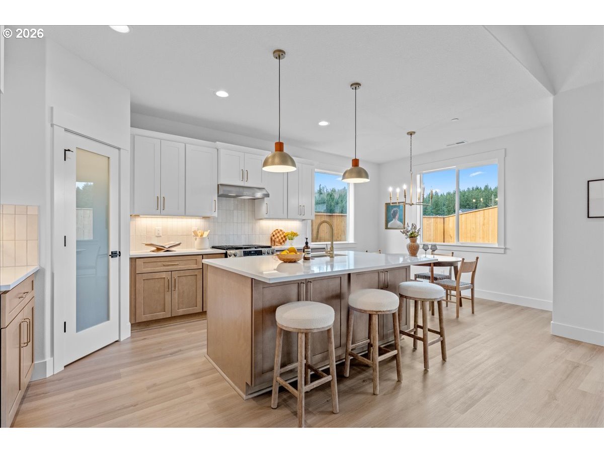 789 Riley Drive Northeast Silverton, OR 97381 - Photo 8 of 24 a kitchen with stainless steel appliances a dining table chairs and wooden floor