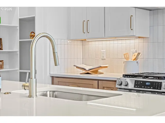 a view of kitchen with stove and cabinets