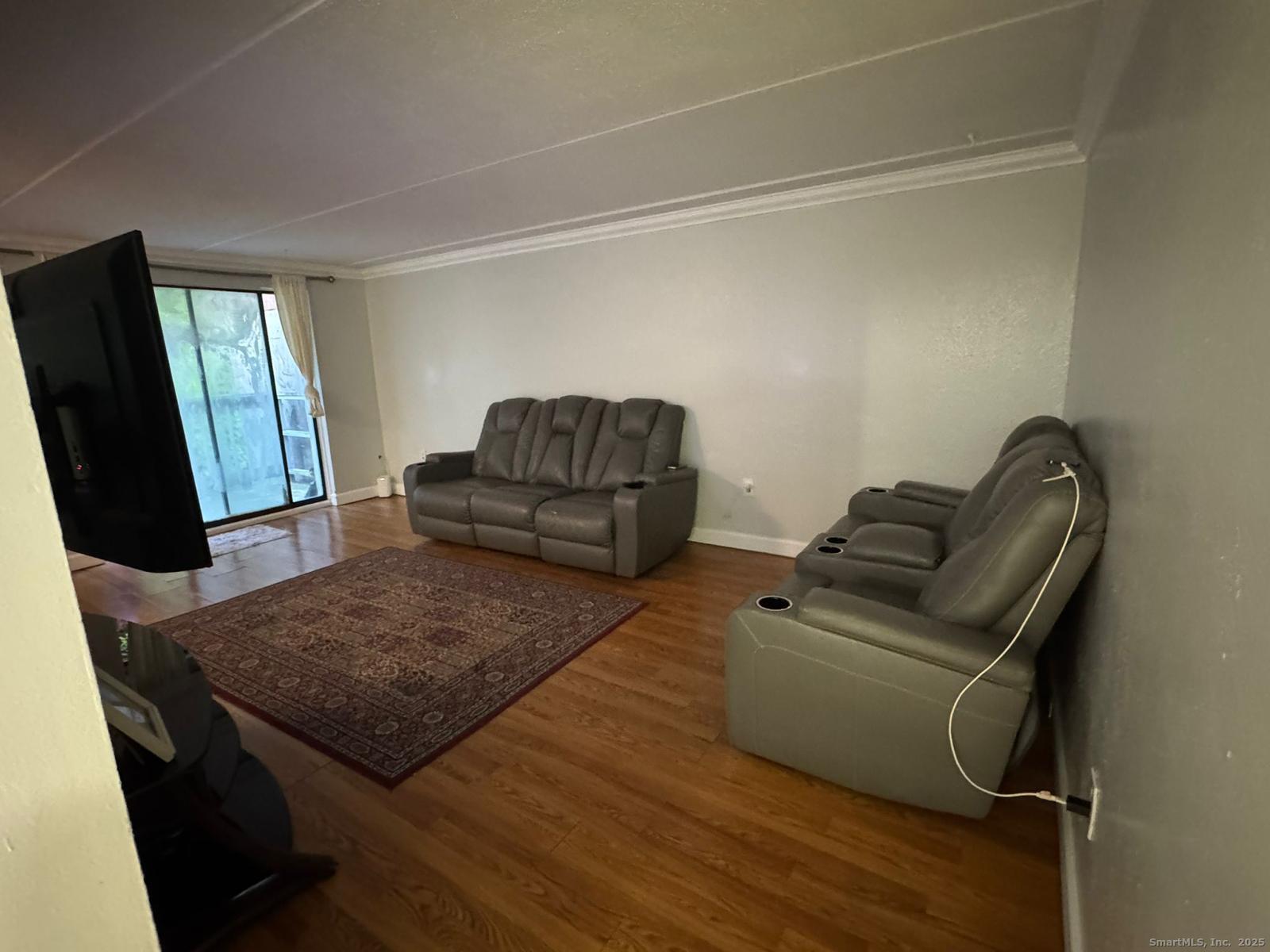 126 Triangle Street, Unit B13 Danbury, CT 06810 - Photo 11 of 29 a living room with furniture and a flat screen tv