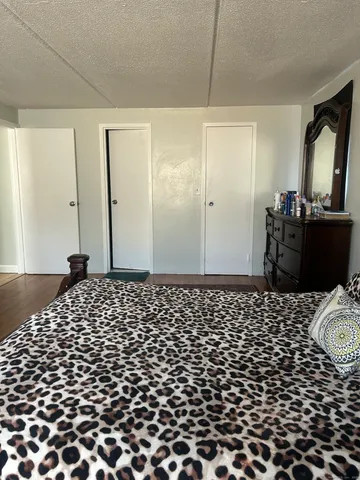 a bedroom with a bed and a mirror on dresser