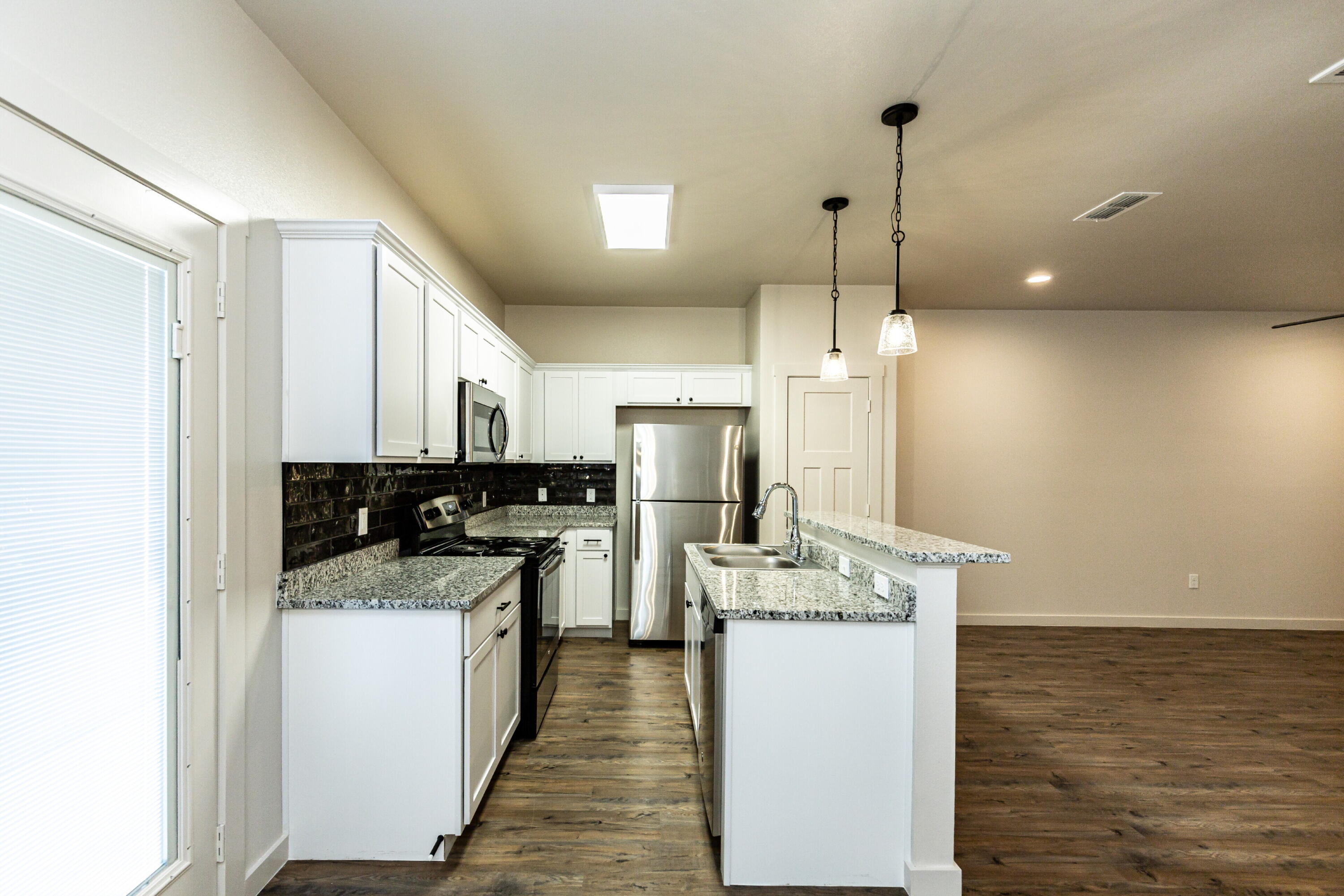 2526 138th Street Lubbock, TX 79423 - Photo 14 of 36 a kitchen with a sink a counter top space stainless steel appliances and cabinets