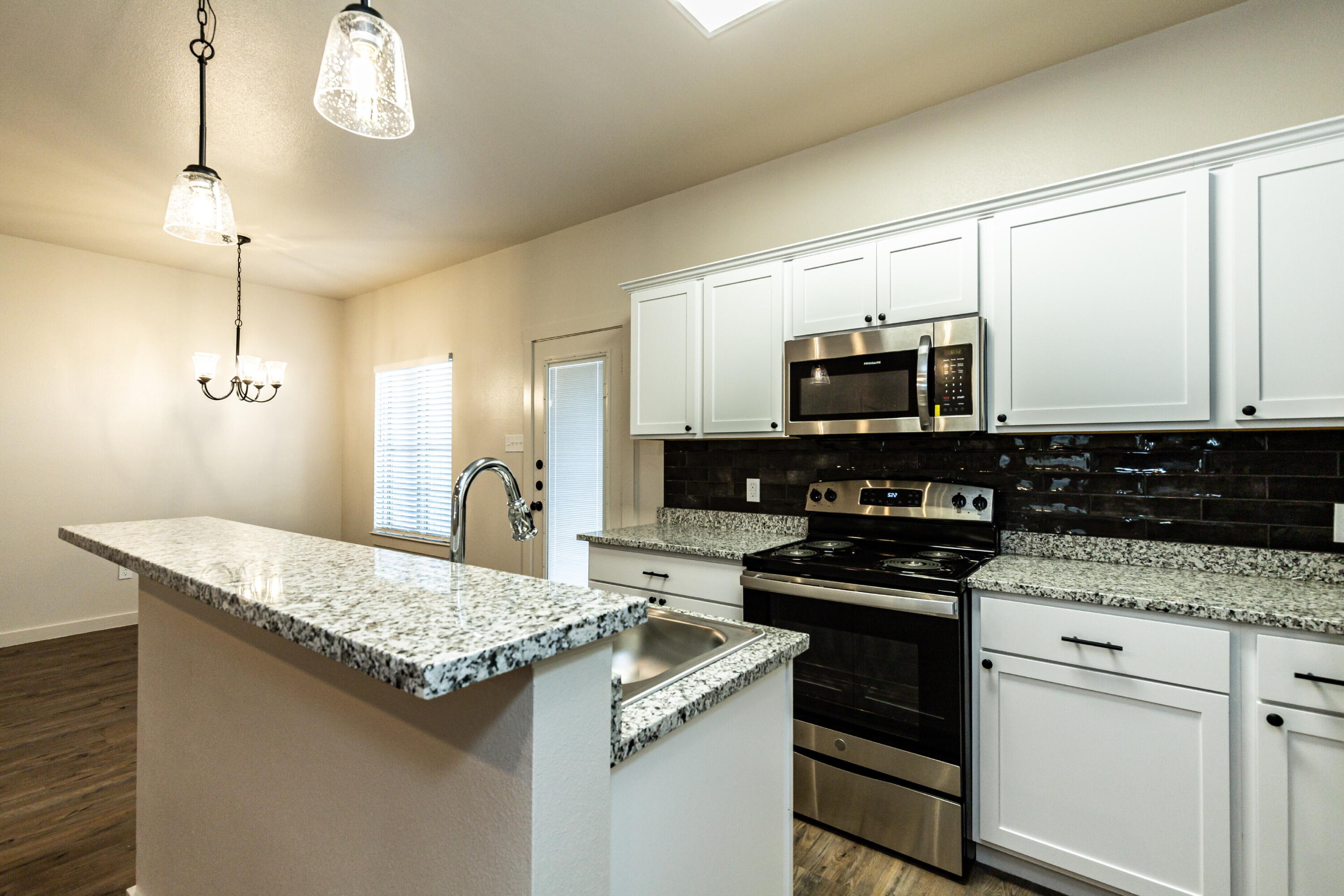 2526 138th Street Lubbock, TX 79423 - Photo 16 of 36 a kitchen with granite countertop a sink a stove and oven