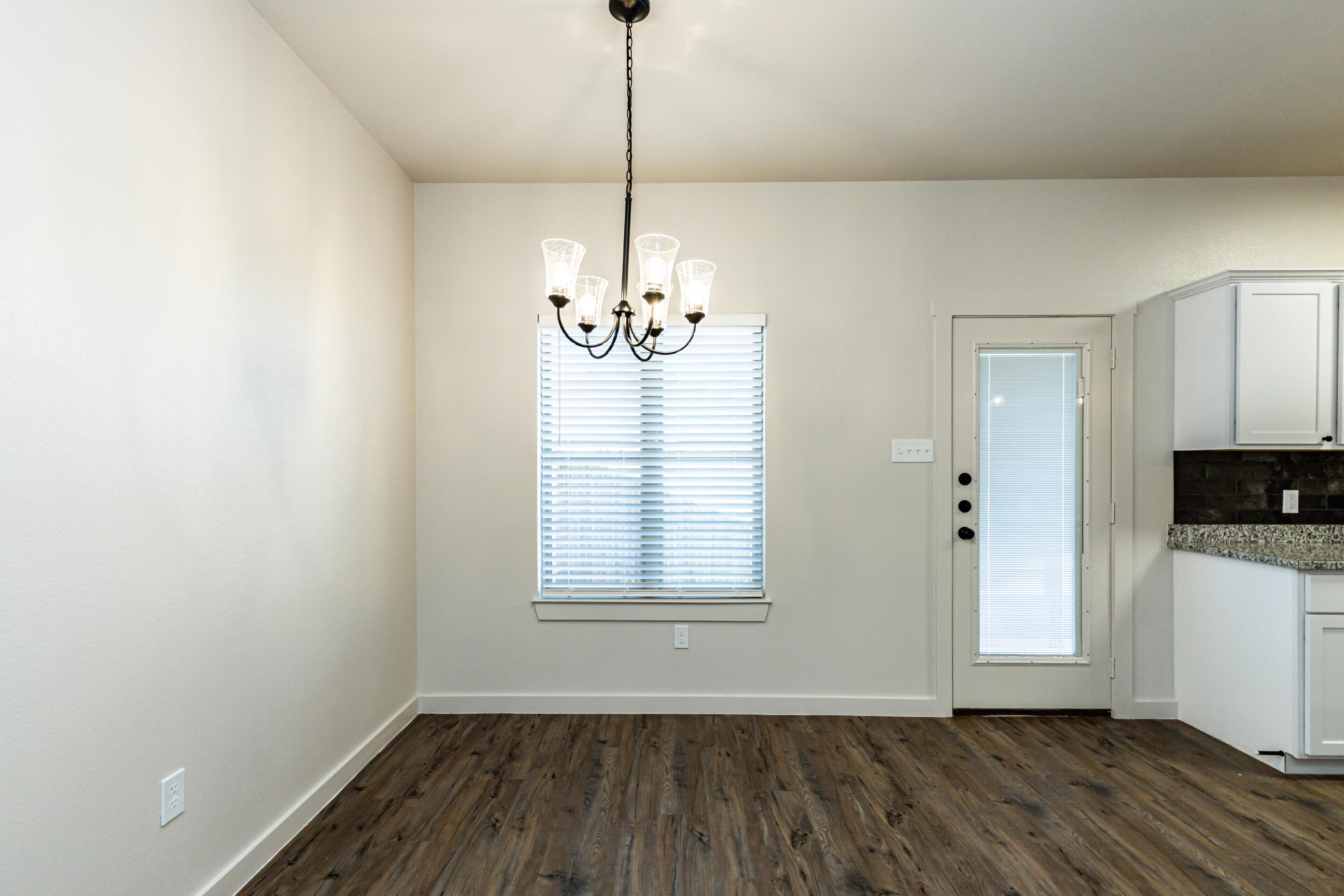 2526 138th Street Lubbock, TX 79423 - Photo 21 of 36 a view of an empty room with window and wooden floor